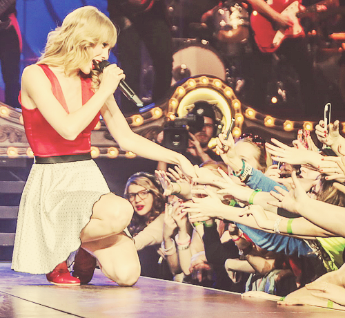 Taylor Swift singing to fans at one of her RED Tour concerts