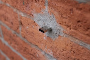 Dead Drop USB drive cemented into a wall